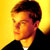 Pixelated static icon of a person with dark hair against a yellow background wearing a black jacket and white shirt.