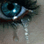A pixelated image split into two sections: a close-up of a blue eye with dark hair on the left, and a light green background with text on the right.