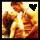 Two side-by-side pixelated images of a person in a white shirt and brown jacket with a black heart symbol on the left and yellow heart on the right.