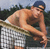 Pixelated image of a shirtless man in white shorts holding a tennis racket, leaning forward with one arm extended.