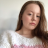 A pixelated static image shows a person with long brown hair wearing a white top with pink accents against a light background.