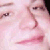 Pixelated close-up of a person's face showing eyes, nose, and mouth with pink and white tones.