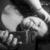 Black-and-white animation of a hand holding a small object with two rounded shapes above it, showing subtle motion in the lower portion.