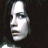 A pixelated image of a woman's face with dark hair and pale skin, overlaid by blue 'UNDERWORLD' text in two separate sections.
