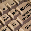 A close-up of beige keyboard keys with black text and symbols, including 'NO WAY!', 'LOL!', 'ILY', 'HA!', 'SEND', 'instant Message', and two smiley face icons.