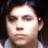 Pixelated close-up of a person's face with dark hair, light skin, and a neutral expression against a dark background.