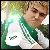 Pixelated static image of a person in green and white clothing with blurred background, likely from an old digital photo or low-resolution source.