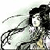 Pixelated figure with long dark hair, light-colored clothing, and a flowing dark accessory against a pale background.
