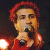 A pixelated contact sheet showing two frames of an animated icon featuring a person with red hair holding a microphone on the left and green text reading "Original Icons .com" on the right against a dark background.