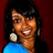 Pixelated image of a person with dark hair wearing large circular earrings and blue clothing against a red background.