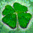 Static pixelated image of a four-leaf clover with green leaves and subtle blue-green background pixels.