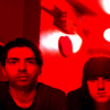 Red-tinted group photo of four people under red lighting with text 'DISTILLERS' and 'PUNX' in alternating colors on black background.