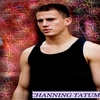 A person in a black sleeveless shirt stands against a blurred red and purple background with visible text at the bottom.