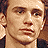 Pixelated image of a person with light brown hair and neutral expression, overlaid with text elements on a dark blue background.