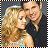 Static pixelated image of two people in close proximity with a filmstrip border, one wearing light blue and the other dark clothing against a gray background.