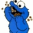 Blue cartoon character with large eyes and brown crumbs around its mouth, holding a cookie in front of a white background.
