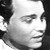 Black-and-white pixelated portrait of a person with short dark hair, neutral expression, and visible ear, cropped to show head and upper shoulders.