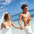 Two pixelated figures in swimwear stand in shallow water under a blue sky, one facing left, the other facing right.