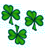 Three green four-leaf clovers with pixelated edges on a gray background with cyan dots, each in slightly different orientations and positions.