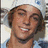 A pixelated image of a smiling person with brown hair wearing a white cap and blue shirt, split into two side-by-side with green text reading 'hot stuff' on the right