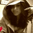 A person with long dark hair wearing a hooded garment, shown in three where the head position shifts slightly left to right