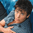 Pixelated image of a person with dark hair wearing a light blue shirt, extending an arm forward against a blurred background.