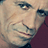 Pixelated close-up of a person's face with visible eyes, nose, and mouth against a dark background.