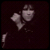 A monochrome animated sequence shows a person with dark hair holding a microphone, transitioning through multiple poses against a solid black background.