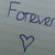 Pixelated blue text 'Forever' and a heart symbol on a light gray background.