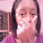 Pixelated static image of a person with dark hair, light skin tone, and pink clothing against a soft pink background.