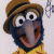 Pixelated character with large eyes, brown hat, and yellow shirt against light background.