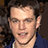 Pixelated image of a person with curly brown hair wearing a dark blue shirt, set against a black background with white text reading THE BOURNE ULTIMATUM.