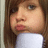 Pixelated close-up of a person with brown hair wearing a white top, showing partial facial features including eyes and lips.