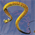 A pixelated golden snake with a black-tipped tail coils against a blue gradient background, its head facing left with a small white eye detail.