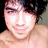 A shirtless person with dark hair appears in three sequential expressions: smiling, neutral, and squinting, against a muted background.