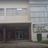 Pixelated static image of a building facade with horizontal bands and dark rectangular openings resembling windows or doors.