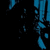 Blue and black pixelated animation of vertical shapes with scattered blue fragments against a dark background.