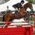 A horse and rider jump over a red obstacle with white padding, while green text overlays change from 'me' to 'thats'.