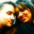 Two people in close proximity with one person's head tilted toward the other, visible in a of four with one empty