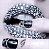 A static image of lips covered in small white and black dots, with a finger holding a black object near the mouth, and partial text reading "Glam" below.