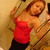 A person in a red tank top and black pants lies on their back holding a phone, with the right side of the image blank.