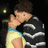Pixelated image of a person in a black and white striped shirt with blue and yellow accents, holding a hand near their face, next to white pixelated text on a black background.