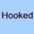Light blue background with dark brown text reading 'Hooked' on left and 'On' on right above a pixelated image of a person with short brown hair wearing a dark shirt.