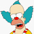 Pixelated cartoon character with light skin, large blue ears, red nose, and open mouth showing teeth and tongue, wearing yellow and red clothing against white background.