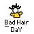 Pixelated character with spiky black hair, white face, and yellow shirt against gray background, with text below reading "Bad Hair Day".