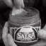 A black-and-white animation of a hand dipping a chip into a jar labeled 'SALSA' with changing chip positions across frames.