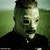A pixelated figure with a pale face and dark eyes wears a black shirt against a green background, showing subtle facial expression changes across frames.