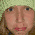 Pixelated image of a person with light brown hair wearing a light green headband, set against a green background.