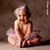 Static pixelated image of a cartoon baby in a pink tutu sitting against a brown background with visible dithering and low-resolution rendering artifacts.