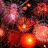 A pixelated static image of multiple overlapping glowing orbs in warm red, orange, and pink hues against a dark background.